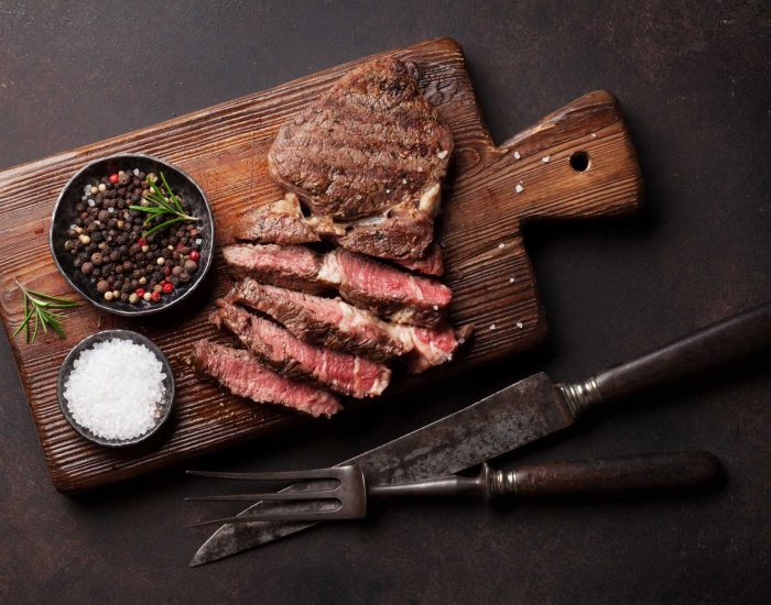 grilled-beef-steak-with-spices-on-cutting-board-PBRZYAX.jpg